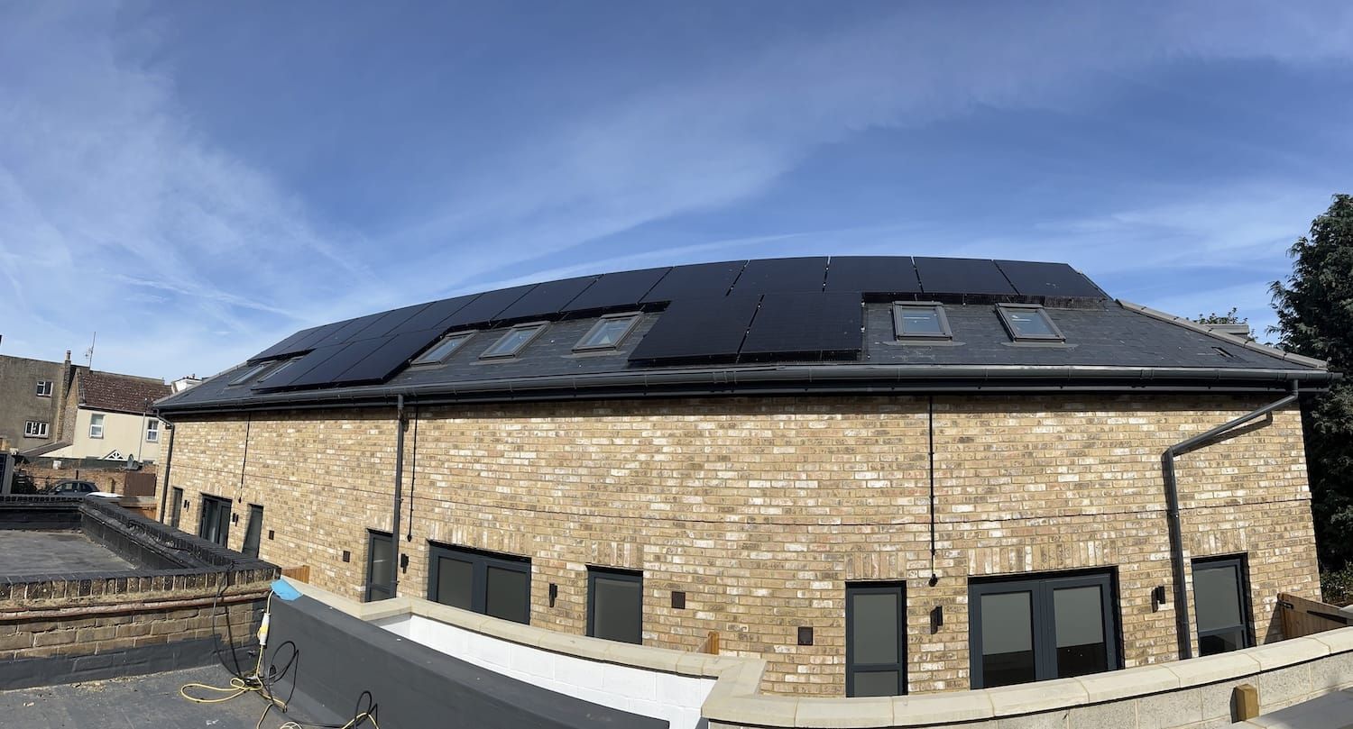 A man on a roof fitting solar panels