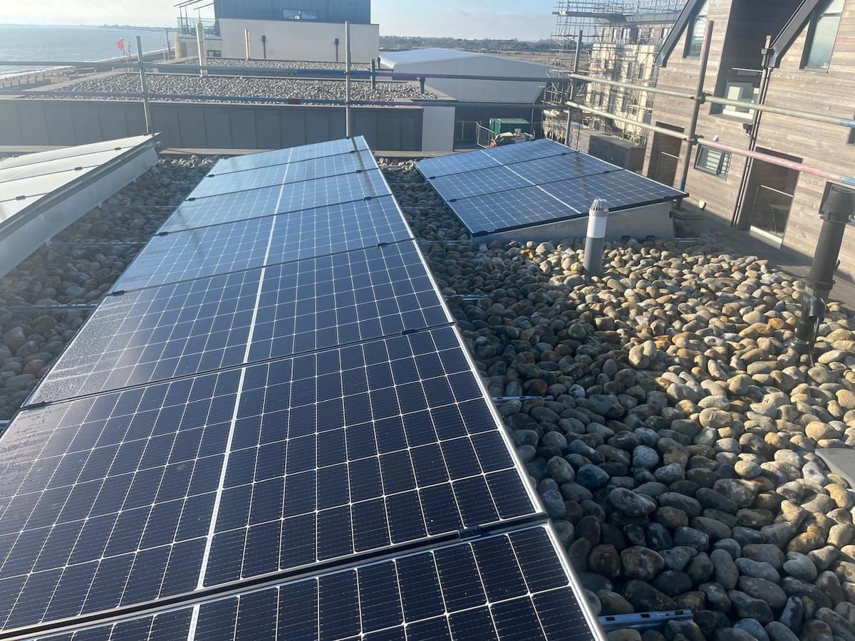 A man on a roof fitting solar panels