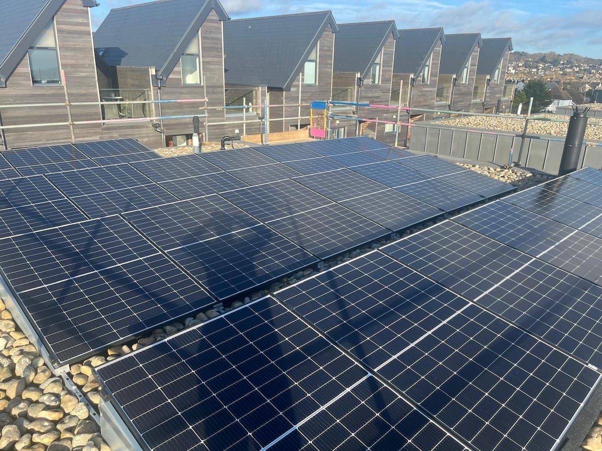 A man on a roof fitting solar panels